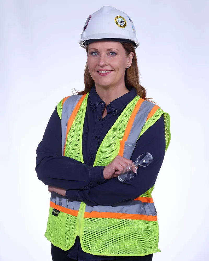 Corporate headshot portrait woman safety vest hard hat crossed arms