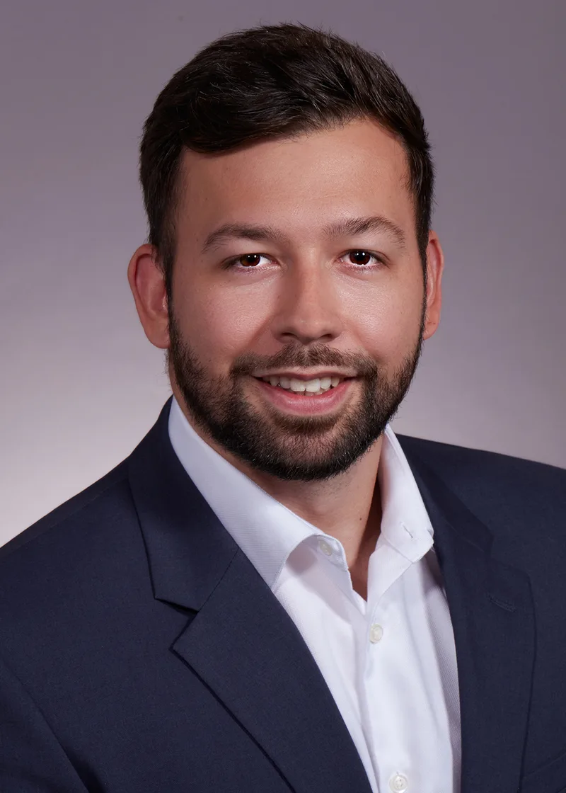 Business professional headshot man navy blazer white shirt studio background