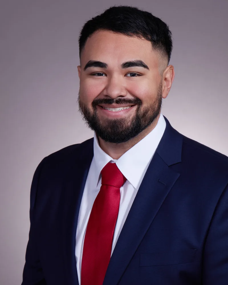 Corporate headshot professional man navy suit red tie neutral background