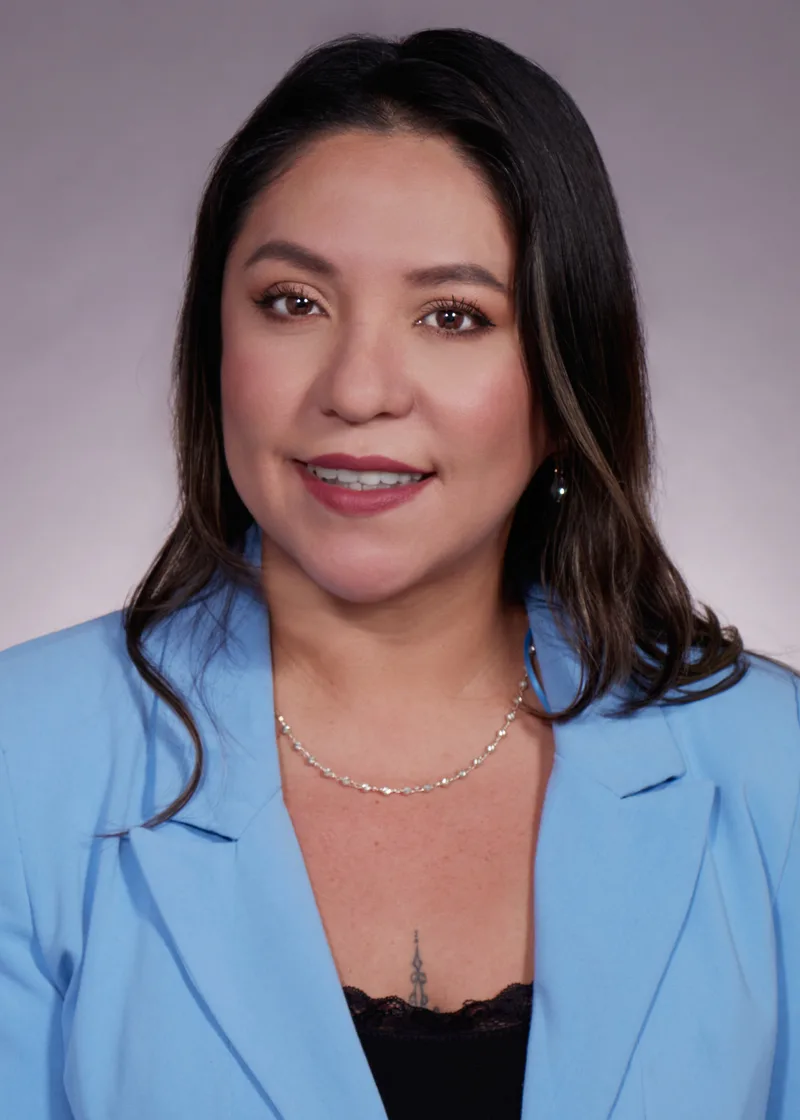 professional woman blue blazer corporate headshot dark hair studio portrait smiling