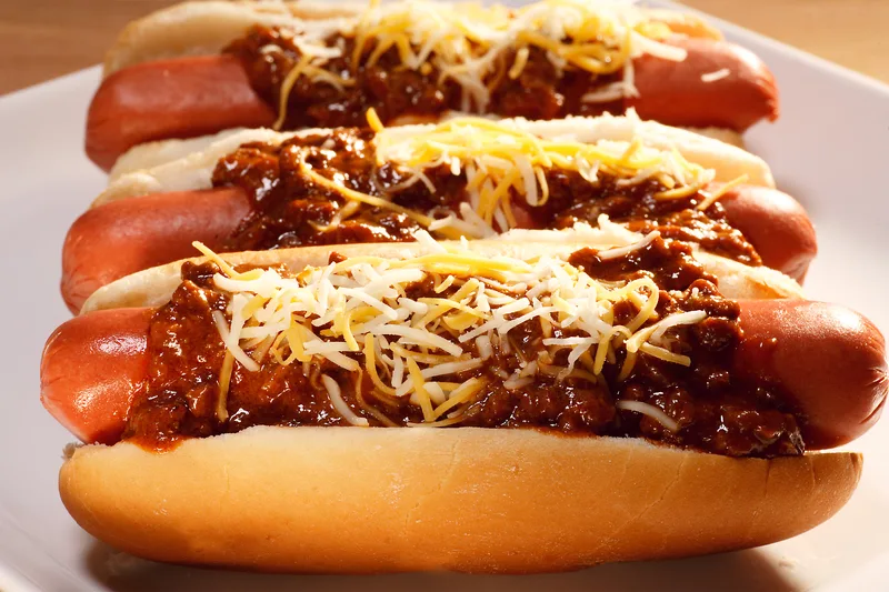 Chili cheese hot dogs smothered in meat sauce and shredded cheddar blend