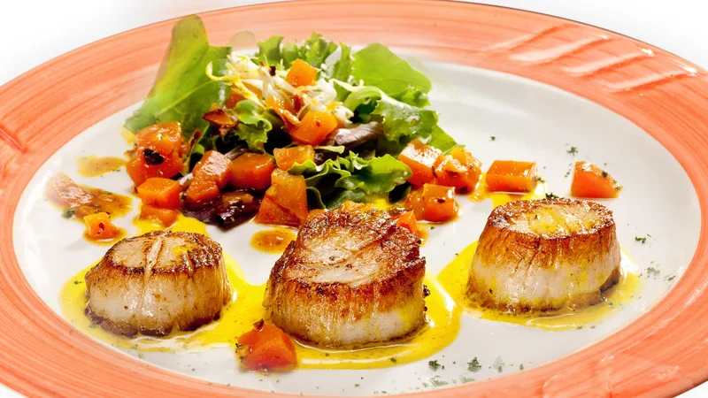 Seared scallops with mixed greens salad and golden citrus butter sauce