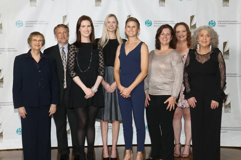 Corporate awards gala group portrait professionals elegant evening attire step-and-repeat backdrop