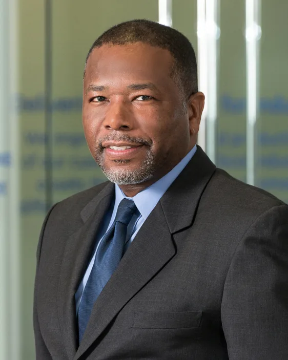 GE Power executive portrait charcoal suit blue tie glass office backdrop