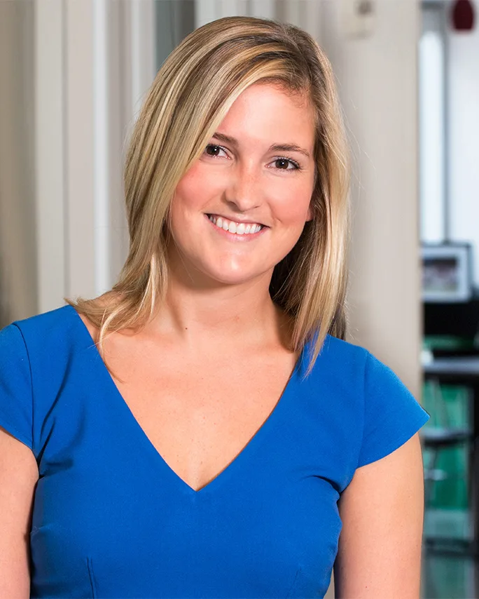 Betsy Hawes professional headshot smiling woman cobalt blue cap-sleeve top