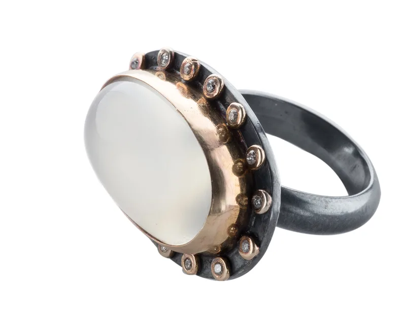 Oxidized silver ring with rose gold bezel, large moonstone cabochon, and diamond halo accents