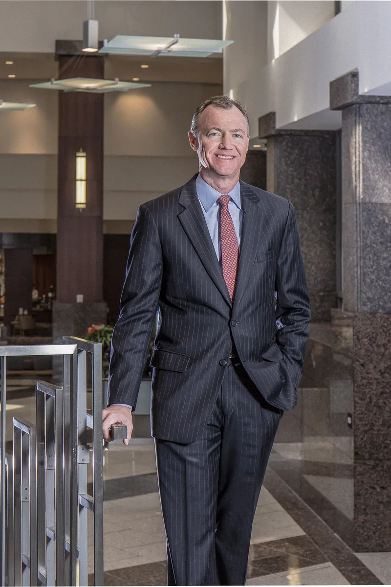 Corporate headshot man charcoal pinstripe suit red tie marble lobby